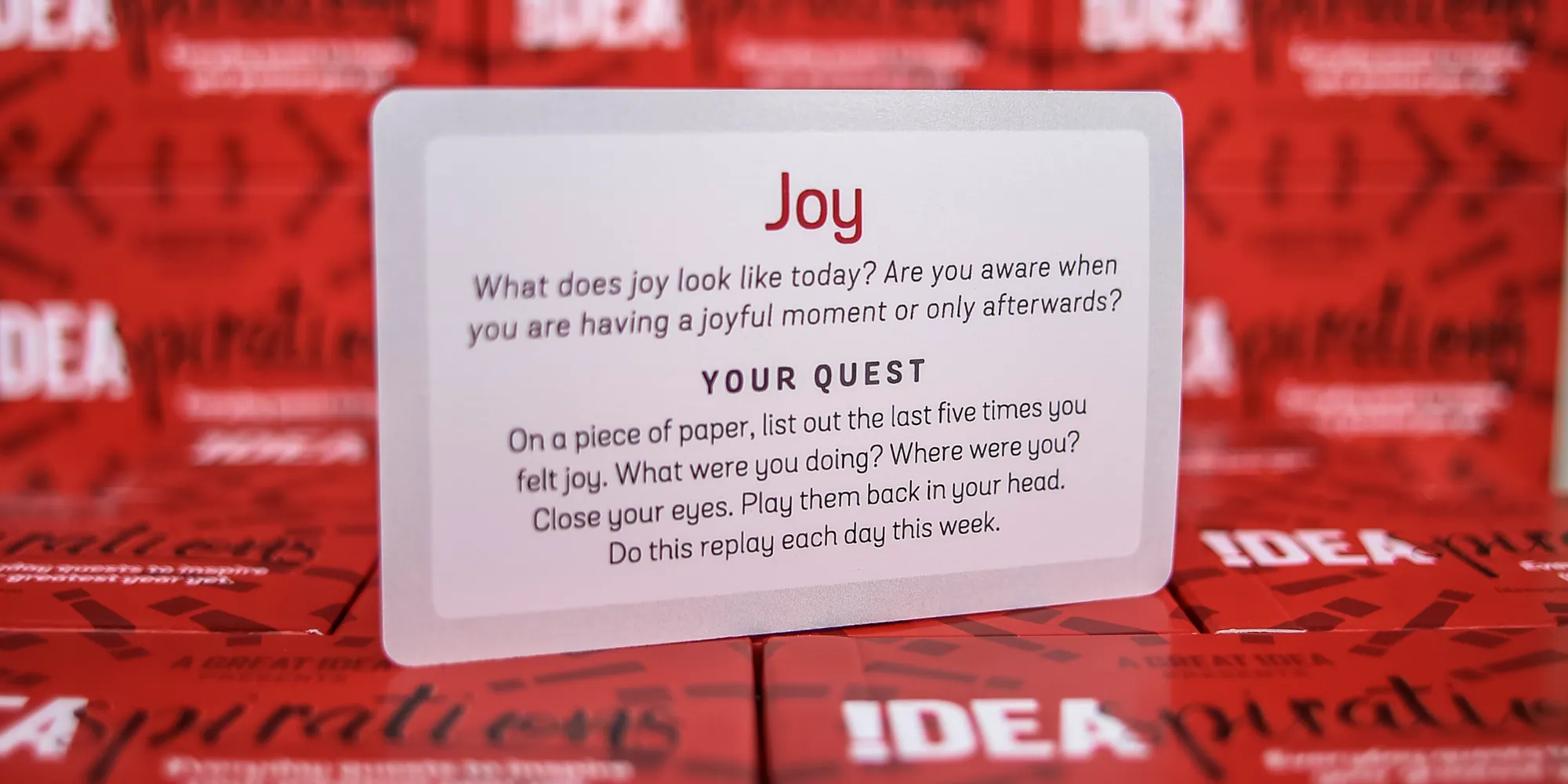 A Joy card standing against a wall of boxed decks